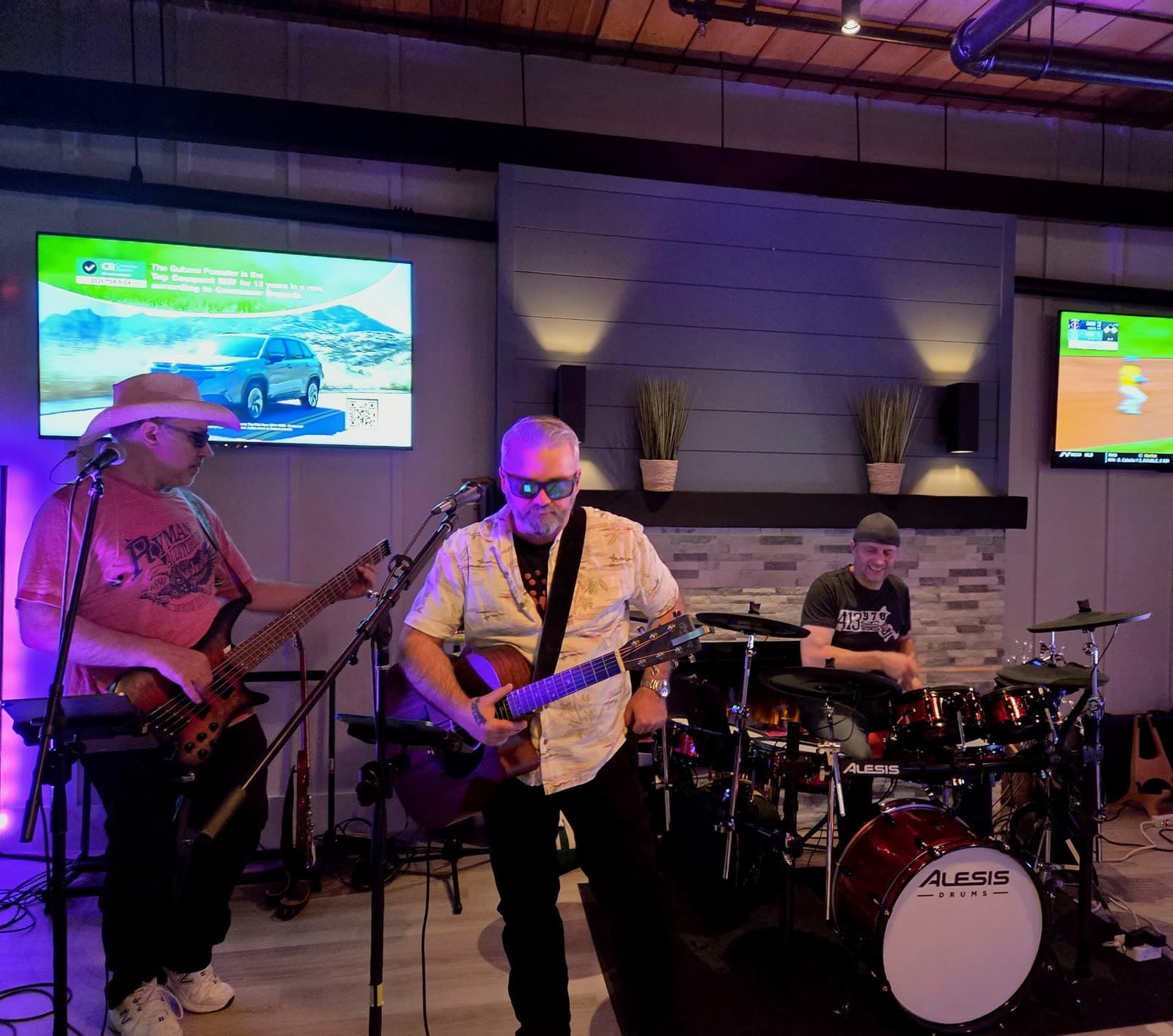 Bassist, guitarist, and drummer performing, alternate moment